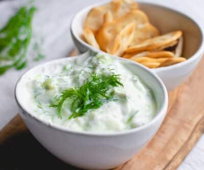 Greek Yogurt Sauce in a white bowl with dill on top