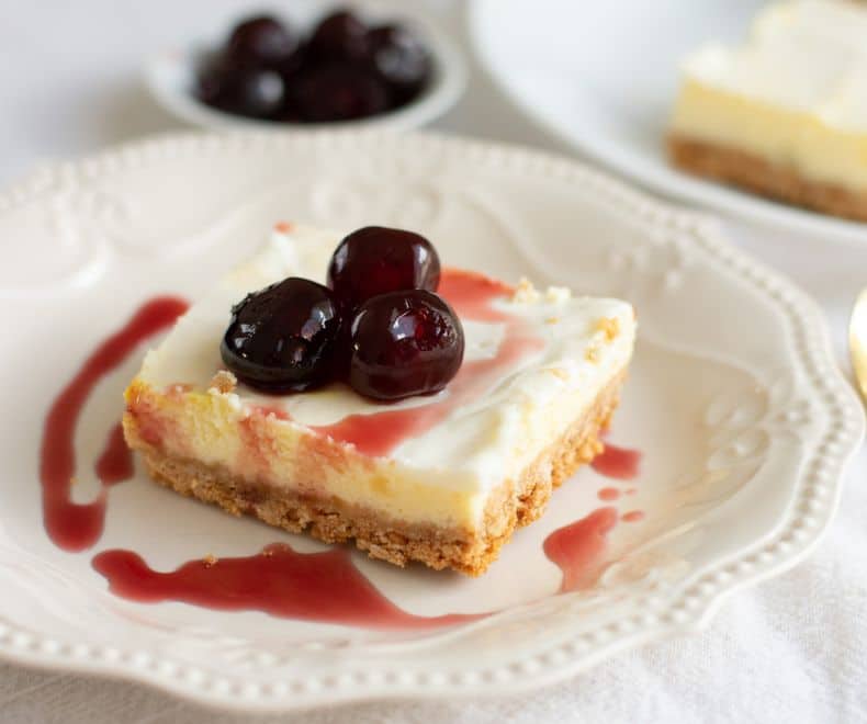 baked cheesecake on a plate with cherries on top
