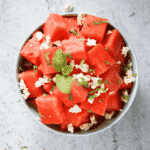 a bowl with watermelon cubes and feta cheese