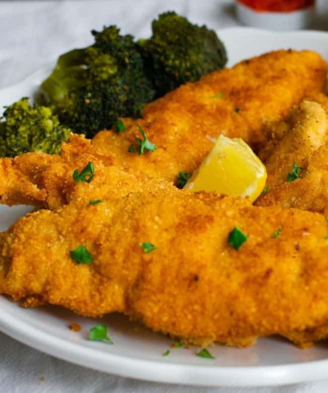 Crispy Passover Chicken Schnitzel on a white plate with broccoli