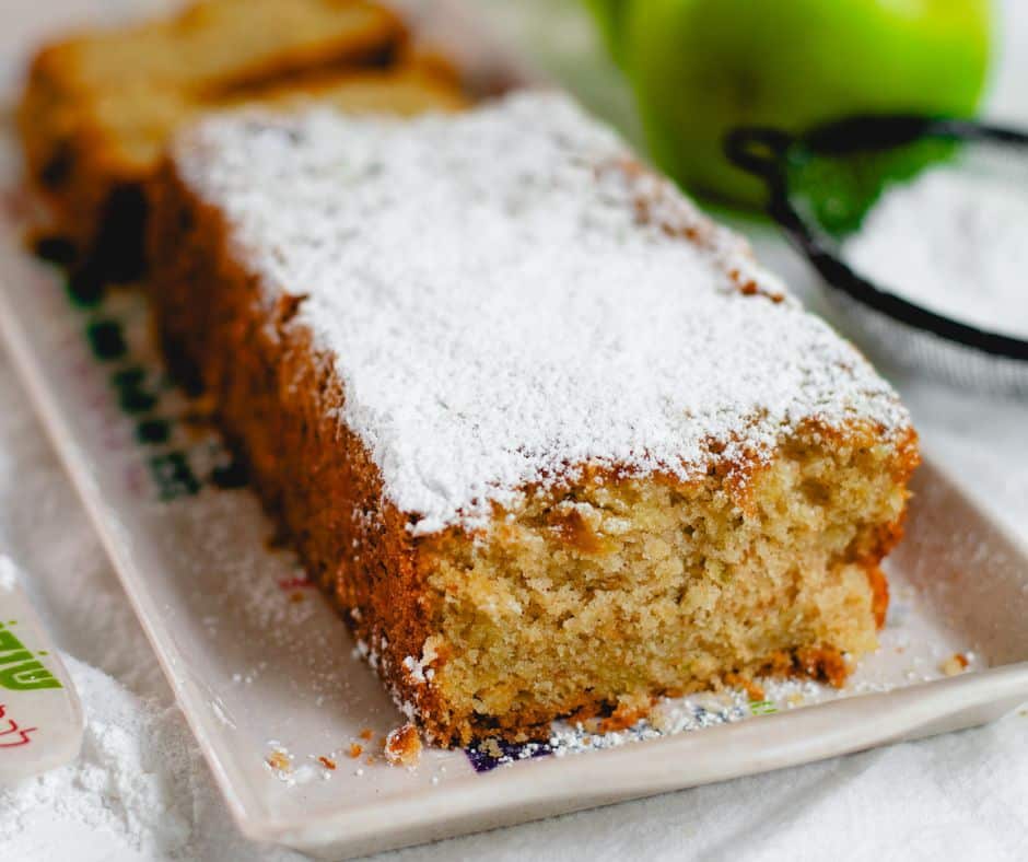 One-Bowl Apple Cake on a white plate with powdered sugar