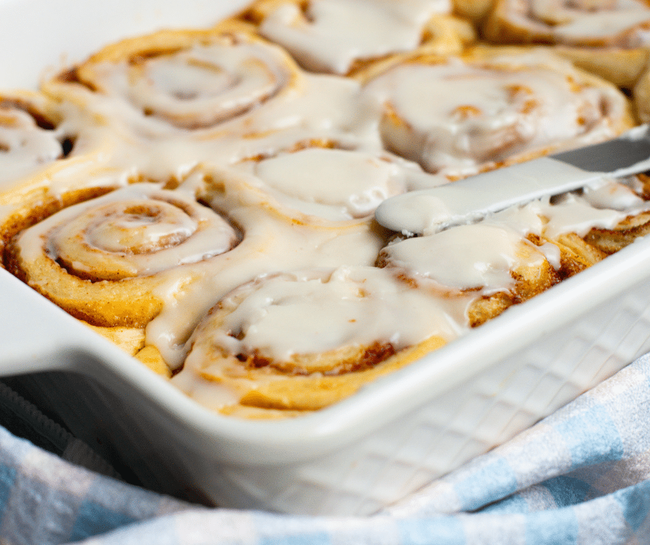 Challah Cinnamon Rolls In a white baking dish with white frosting