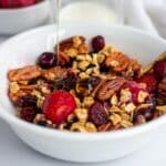 Maple Pecan Granola in a white bowl with berries