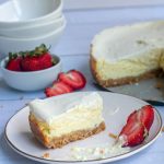 Baked Cheesecake slice on a white plate with strawberries