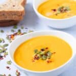 two bowls of Pumpkin Sweet Potato Soup with pumpkin seeds