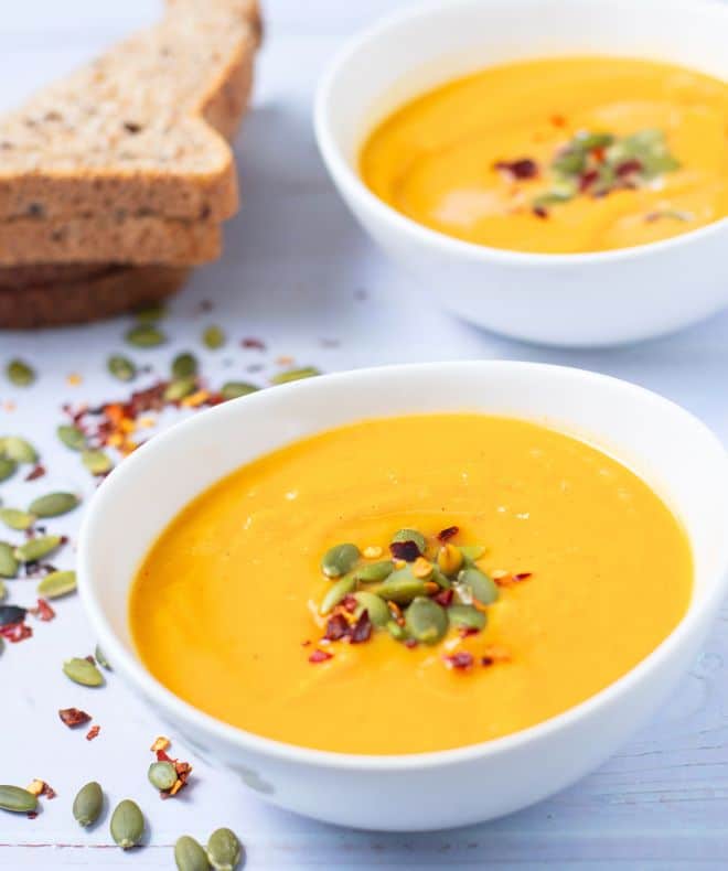 two bowls of Pumpkin Sweet Potato Soup with pumpkin seeds