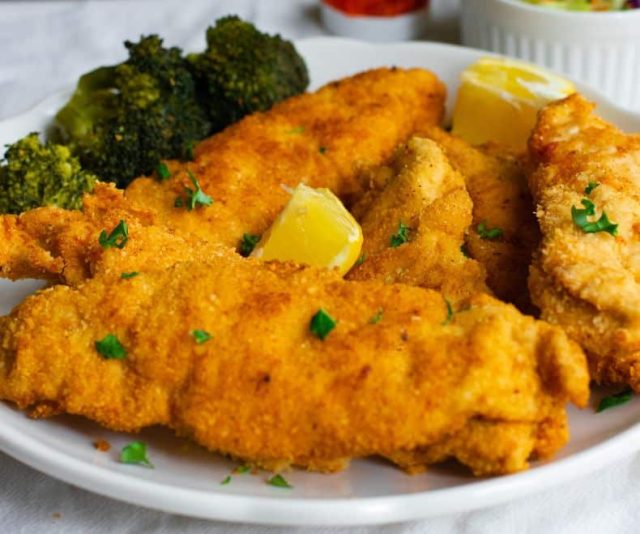 Crispy Passover Chicken Schnitzel on a white plate with broccoli